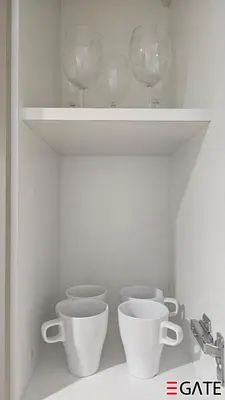 a shelf with three cups and wine glasses on it at EGATE - Studio - 2nd Floor with Balcony - Dubai - 33-212 in Dubai