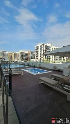 a resort with a swimming pool and some buildings at EGATE - Studio - 2nd Floor with Balcony - Dubai - 33-212 in Dubai
