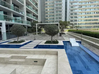 a courtyard in a building with a bench and trees at Luxury2BR Canal View Free parking & water Downtown in Dubai