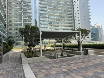 a pavilion with tables and chairs in front of a building at Luxury2BR Canal View Free parking & water Downtown in Dubai