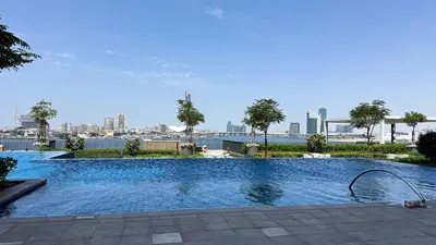 a large swimming pool with a city in the background at Luxury 2BHK & Lagoon view in Dubai