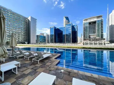 a swimming pool with a city skyline in the background at Burj Khalifa View - 4 min Dubai Mall - SwimingPool - Business Bay in Dubai