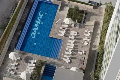 an overhead view of a swimming pool with many white resorts at Burj Khalifa View - 4 min Dubai Mall - SwimingPool - Business Bay in Dubai