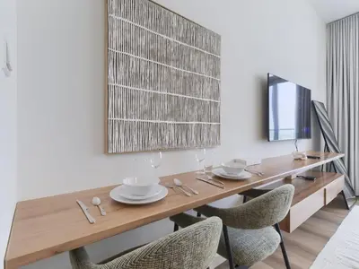 a dining room with a wooden table and chairs at TRPS - Carson Tower B, DAMAC Hills - Brand New Luxury Studio Apartment in Dubai