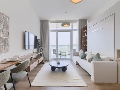a living room with a white couch and a table at TRPS - Carson Tower B, DAMAC Hills - Brand New Luxury Studio Apartment in Dubai