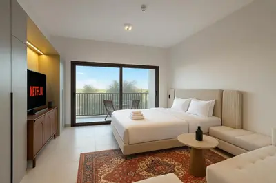 a bedroom with a bed and a tv and a couch at Sleek New Studio in Meydan, Fully Equipped and Spacious in Dubai