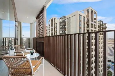 a balcony with chairs and a table and some buildings at Family 2BR Near Creek, Shops, Dining & Top Attractions in Dubai