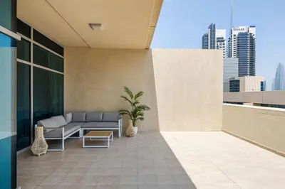 a balcony with a couch and a plant on a building at 1BR plus Extra Bedroom Bay Square B7, City View in Dubai