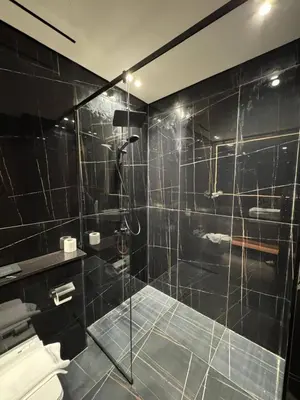 a bathroom with a shower with a glass door at Cozy 1br With Elegant Interiors! in Dubai