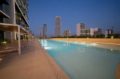 a swimming pool with a city skyline in the background at Cozy 1br With Elegant Interiors! in Dubai