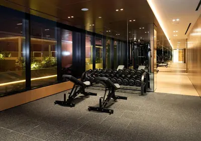 a gym with chairs and treadmills in a building at Cozy 1br With Elegant Interiors! in Dubai