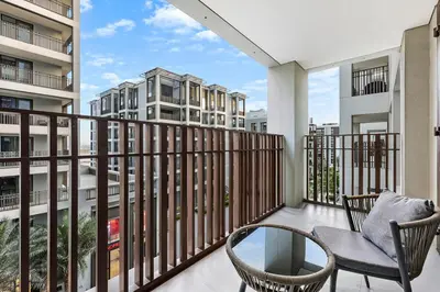 a balcony with two chairs and a table and some buildings at FIRST CLASS 2BR Design Meets Comfort in Dubai