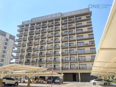 a large building with cars parked in front of it at Modern Cozy Studio in Dubai