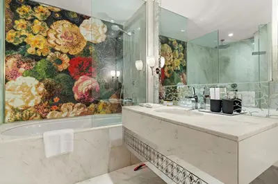 a bathroom with a large painting of flowers on the wall at FIRST CLASS Studio Stunning Burj Khalifa Views in Dubai