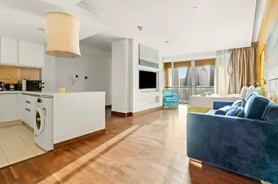 a large kitchen and living room with a blue couch at FIRST CLASS Studio Stunning Burj Khalifa Views in Dubai