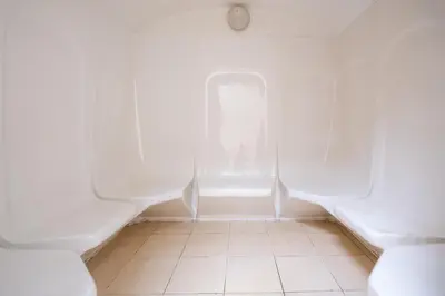 a bathroom with white urinals and a tiled floor at Studio Nova at Dubai Sports City in Dubai