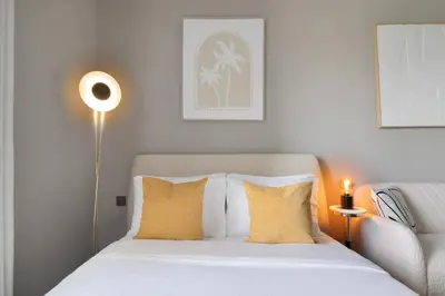 a bedroom with a white bed with yellow pillows at Studio Nova at Dubai Sports City in Dubai