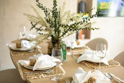 a table with wine glasses and a vase with flowers at 41st-Floor 2BR with World's Highest Running Track in Dubai
