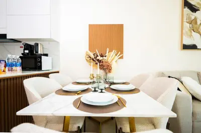 a dining room with a white table and chairs at Luxury 1BR on High Floor JVC in Dubai