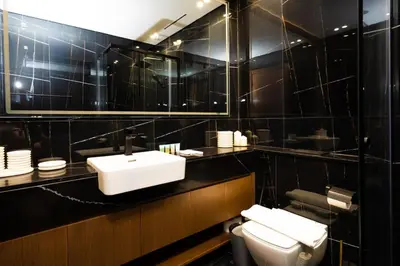 a black tiled bathroom with a sink and a toilet at Luxury 1BR on High Floor JVC in Dubai