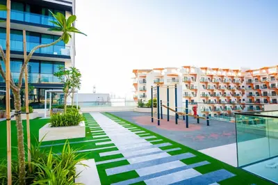 an apartment complex with a courtyard with palm trees at Elegant 1BR with High Rise JVC in Dubai