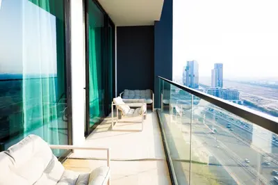 a balcony with chairs and a view of a city at Elegant 1BR with High Rise JVC in Dubai