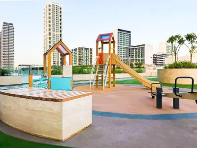 a playground with a slide and a bench in a park at Elegant 1BR with High Rise JVC in Dubai