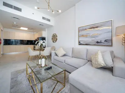 a living room with a couch and a table at Bright and Spacious 1 Bed Prime JVC Location in Dubai