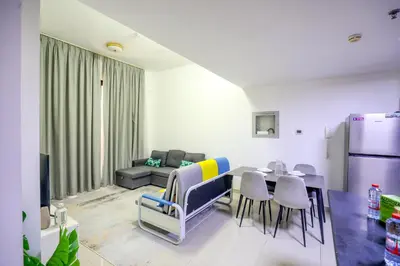 a living room with a table and chairs and a couch at IDLE 1Bed Marina POOL &JBR BEACH in Dubai