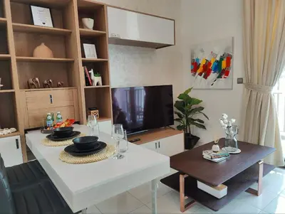 a living room with a white table and a tv at Modern Studio with free Netflix - Close to Metro in Dubai