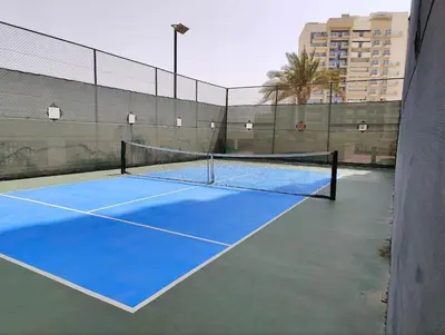 a tennis court with a net on top of it at Modern Studio with free Netflix - Close to Metro in Dubai
