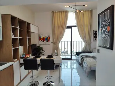 a bedroom with a bed and a desk with chairs at Modern Studio with free Netflix - Close to Metro in Dubai