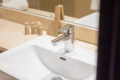 a bathroom sink with a faucet in front of a mirror at Charming Studio Retreat -Few steps away from Ocean in Dubai