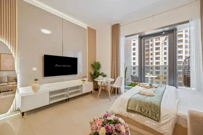 a bedroom with a bed and a flat screen tv at Charming Studio Retreat -Few steps away from Ocean in Dubai