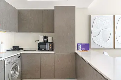 a kitchen with a washer and dryer on a counter at Silkhaus 1BDR Holiday Stay at Pantheon Elysee in JVC in Dubai
