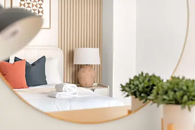 a bedroom with a bed with a mirror at Silkhaus 1BDR Holiday Stay at Pantheon Elysee in JVC in Dubai