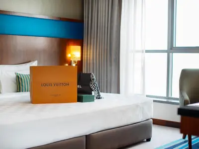a hotel room with a bed with a box on it at Flora Al Barsha Hotel At The Mall in Dubai