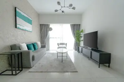 a living room with a couch and a tv at Nasma Luxury stays - Executive stay in the Heart of Dubai Financial Hub in Dubai