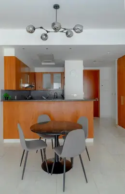 a dining room with a table and chairs and a kitchen at Nasma Luxury stays - Executive stay in the Heart of Dubai Financial Hub in Dubai