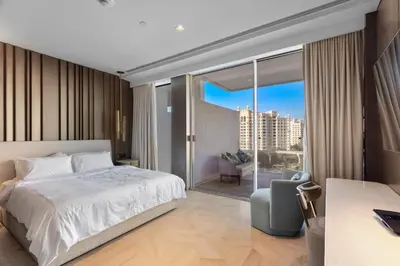 a bedroom with a bed and a large window at Sea View 2BDR Apartment, Pool and Beach Access in Dubai