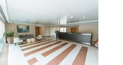 a large room with a couch and a table at Vogue The Greens Al Alka near Mall of the Emirates, One Bedroom Apartment with Balcony and Vibrant community View, Access to all Amenities in Dubai