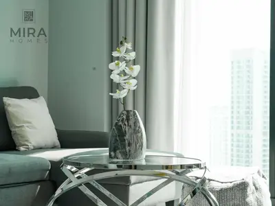 a glass table with a vase on top of it at Mira Holiday Homes - Lovely and luxury 1 bedroom in Address JBR in Dubai