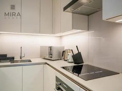 a kitchen with white cabinets and a sink at Mira Holiday Homes - Lovely and luxury 1 bedroom in Address JBR in Dubai