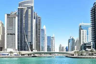 a bridge over a river in a city with tall buildings at Frank Porter - Time Place Tower in Dubai