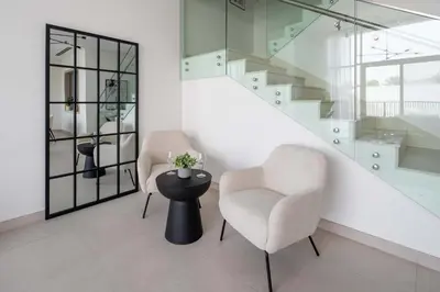 two chairs and a table in a room with stairs at Frank Porter - Murooj Al Furjan West in Dubai