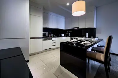 a kitchen with a black island with a table and chairs at Modern 1-Bedroom in Address Marina, City View - 20AB01 in Dubai