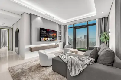 a living room with a couch and a tv at Panoramic Burj Views, Famous Infinity Pool, Balcony Mini Golf - Paramount Midtown in Dubai