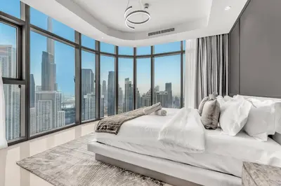 a bedroom with a large white bed and large windows at Panoramic Burj Views, Famous Infinity Pool, Balcony Mini Golf - Paramount Midtown in Dubai