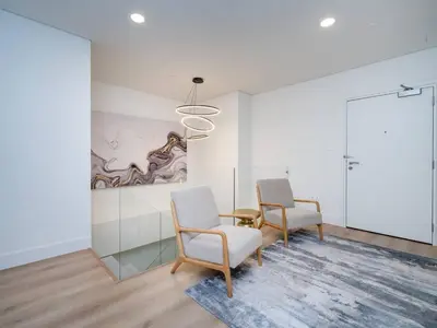 two chairs and a table in a room with a painting at Stunning 2-Bedroom Duplex in Dubai Marina in Dubai