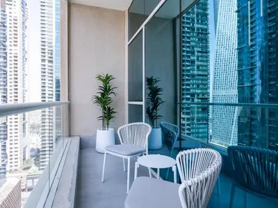 a balcony with chairs and tables on a building at Stunning 2-Bedroom Duplex in Dubai Marina in Dubai